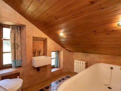 a bathroom with a white tub and a sink at Dovecot Cottage in Ambleside