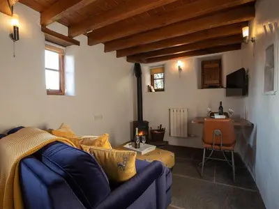 a living room with a blue couch and a table at Dovecot Cottage in Ambleside