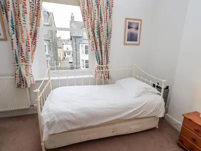 a bedroom with a bed and a window with curtains at Number Twenty in Keswick