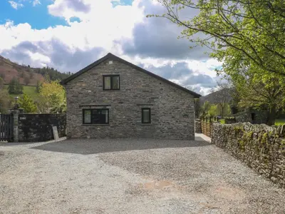 a stone house on a gravel driveway at Rowanberry Cottage in Grasmere