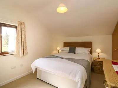 a bedroom with two beds and a window at Rowanberry Cottage in Grasmere