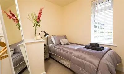 a bedroom with a bed with a teddy bear on it at Greengarth in Keswick