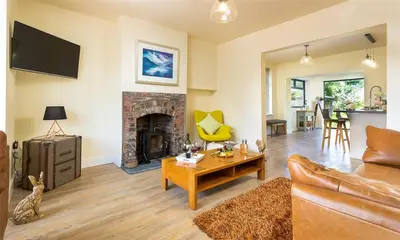 a living room with a couch and a fireplace at Greengarth in Keswick