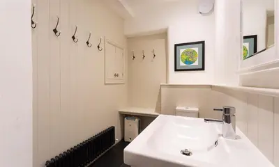 a white bathroom with a sink and a mirror at Ben House in Grasmere