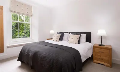 a white bedroom with a large bed and a window at Ben House in Grasmere
