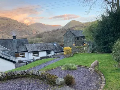 a house with a sheep grazing in a yard at Felldale in Glenridding