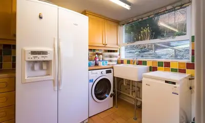 a kitchen with a white refrigerator and a washing machine at Felldale in Glenridding