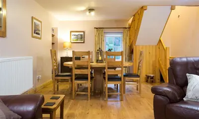 a living room with a dining room table and chairs at Scalegill House in Cockermouth
