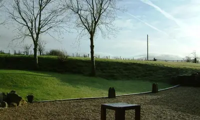 a park with a bench and trees in a field at Scalegill House in Cockermouth