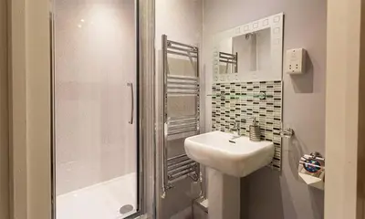 a white bathroom with a sink and a shower at Heathfield in Keswick