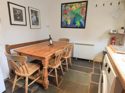 a kitchen with a wooden table and chairs at Holme Ground Cottage in Coniston