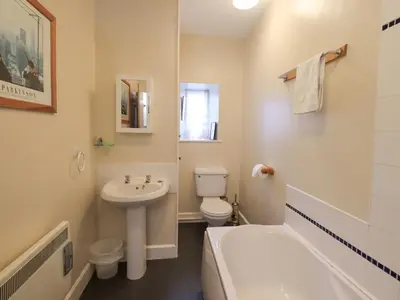 a bathroom with a sink and a toilet and a tub at Holme Ground Cottage in Coniston
