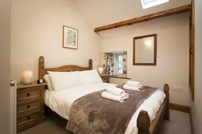 a bedroom with a large bed with towels on it at Wythebank in Ambleside
