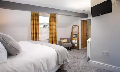 a bedroom with a bed and a television on a wall at Little Leveret Cottage in Keswick