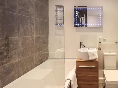 a bathroom with a tub and a sink and a toilet at Le Chalet in Elterwater