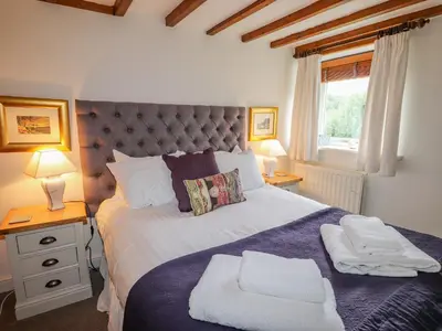 a bedroom with a large bed with two towels on it at Glen View Cottage in Ambleside