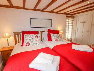 two red and white beds in a room at Glen View Cottage in Ambleside
