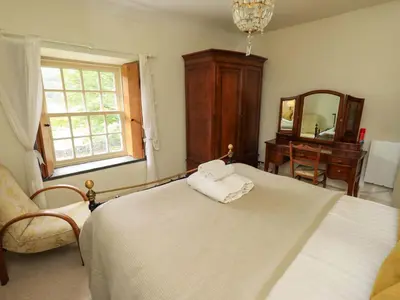 a bedroom with a bed and a chair and a mirror at Beck Steps in Chapel Stile