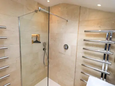 a shower in a bathroom with a glass door at Beck Steps in Chapel Stile