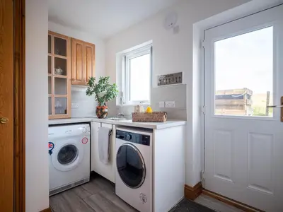 a laundry room with a washer and dryer and a window at Sherriff in Penrith