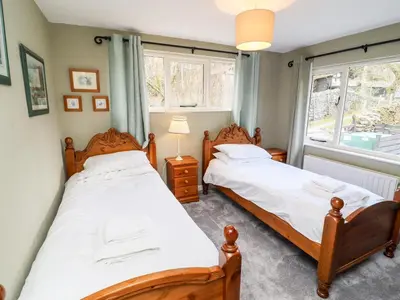 two beds in a bedroom with a window at Gunpowder Cottage in Elterwater