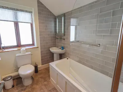 a bathroom with a tub and a toilet and a sink at Croft in Grasmere