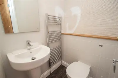 a white bathroom with a sink and a toilet at Gable End in Keswick