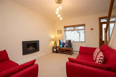 a living room with two red couches and a fireplace at Gable End in Keswick
