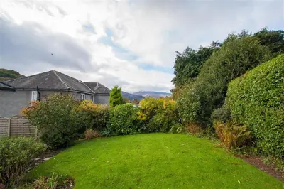 a yard with a green lawn in front of a house at The Haven in Keswick