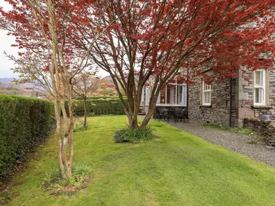 two trees in a yard next to a house at Holmdale in Ambleside