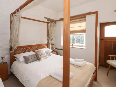 a bedroom with a four poster bed and a window at Underfell in Ambleside