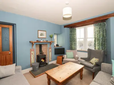 a living room with a table and a fireplace at Underfell in Ambleside