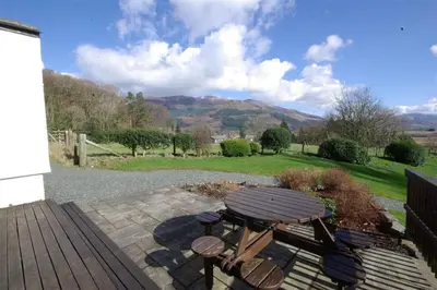 a wooden picnic table and chairs on a patio at Pen Cottage in Keswick