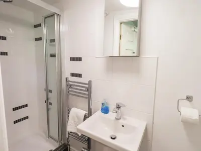 a white bathroom with a sink and a shower at Drystones in Grasmere