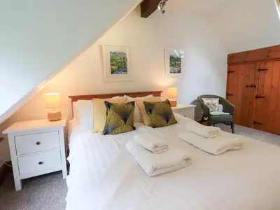 a bedroom with a large white bed with two pillows at Drystones in Grasmere