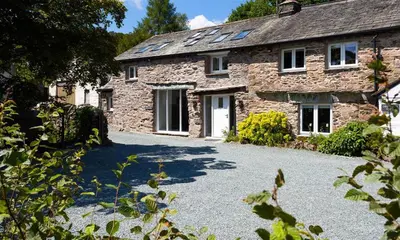 a stone house with a driveway in front of it at Underhowe in Grasmere