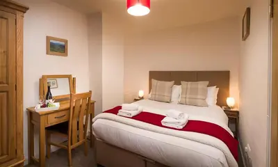 a bedroom with a bed with two towels on it at The Cats Bield in Keswick
