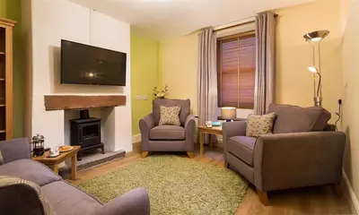 a living room with two couches and a fireplace at The Cats Bield in Keswick