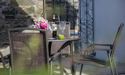 a table with a bottle of wine and flowers on it at Scots Pine in Keswick