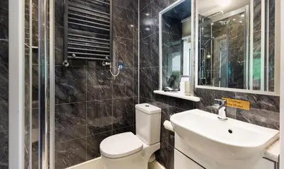a bathroom with a toilet and a sink and a mirror at Scots Pine in Keswick