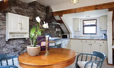 a kitchen with a wooden table with a plant on it at High Raise in Grasmere