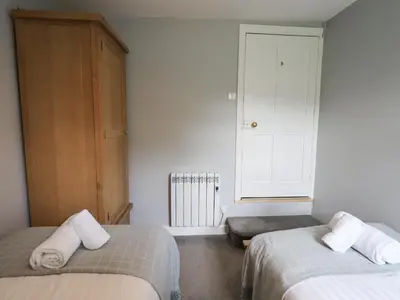 a bedroom with two beds and a window at The Smithy in Borrowdale Valley