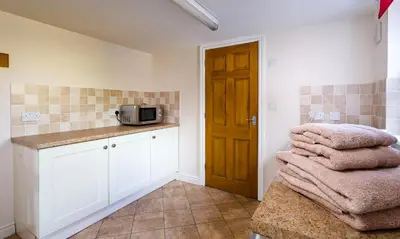 a kitchen with a microwave and towels on a counter at Low Longthwaite Farm in Watermillock