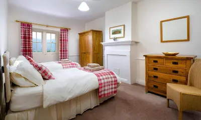 a bedroom with a bed with a teddy bear on it at Low Longthwaite Farm in Watermillock
