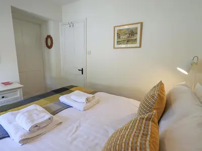 a bedroom with two towels sitting on a bed at Rowan Cottage in Grasmere