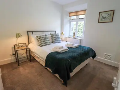 a bedroom with a bed with two towels on it at Rowan Cottage in Grasmere