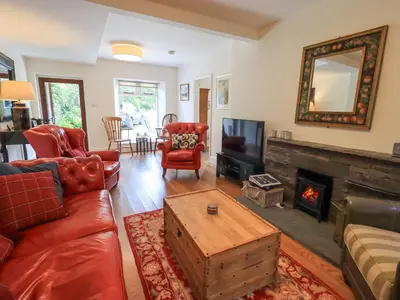 a living room with a couch and a fireplace at Rowan Cottage in Grasmere