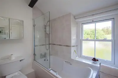 a bathroom with a tub and a sink and a shower at Swinside Cottage in Keswick
