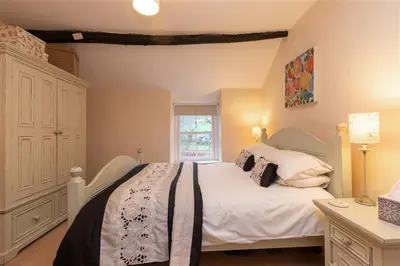 a bedroom with a white bed and a window at Swinside Cottage in Keswick