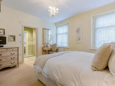 a bedroom with a bed and a dresser and a television at Oak House in Keswick